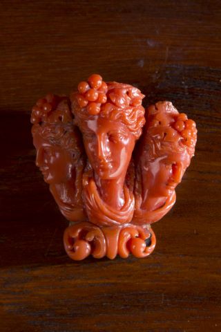 Broche figurant trois visages de femmes