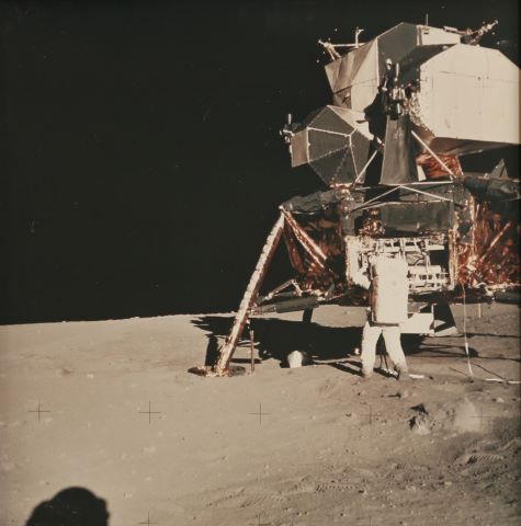 Buzz Aldrin récupérant des instruments dans un compartiment du module,…