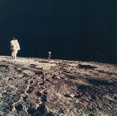 Alan Bean marchant devant l’objectif de la caméra posée au…