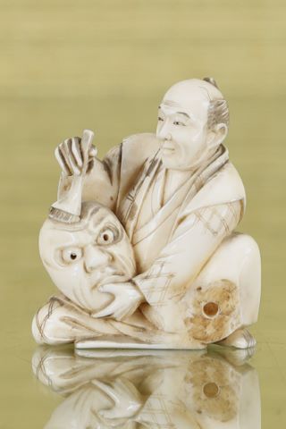 Sujet représentant un artisan peignant un masque