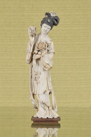 Statuette de guanyin représentée debout tenant une fleur de lotus…