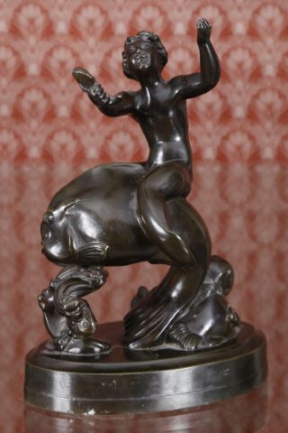 Jeune triton chevauchant un poisson